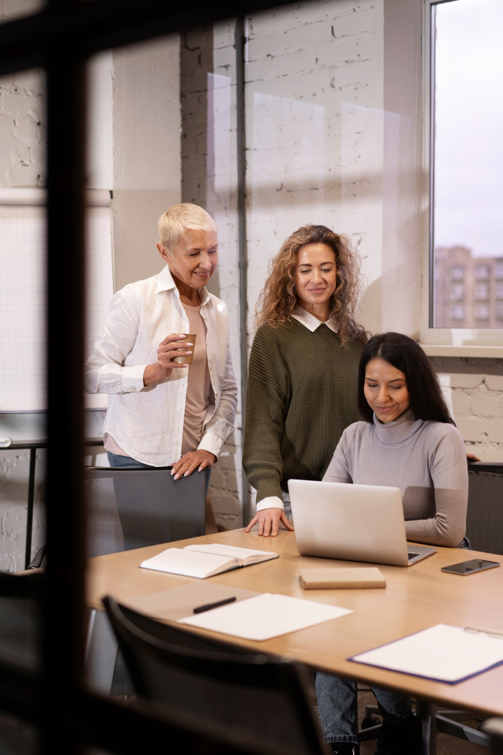 Colleagues reviewing work at a laptop